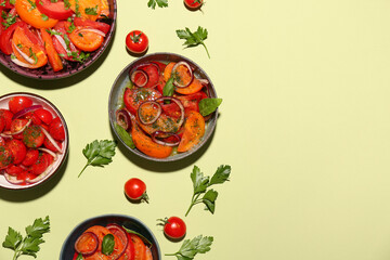 Bowls of fresh tomato salad with red onion and parsley on yellow background