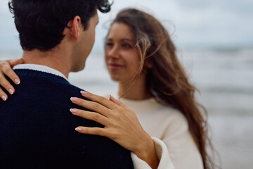 Fototapeta premium Romantic couple embracing on a beautiful beach, sharing a tender moment filled with love and joy as ocean waves gently lap the shore
