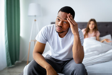 Negative emotions, problems, quarrel. Young black guy feeling upset, his wife yelling at him in...