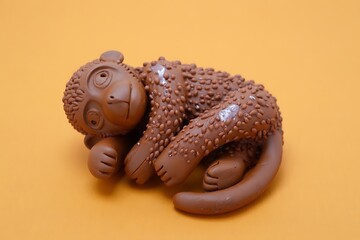 Brown Monkey Toy with Textured Body on a Yellow Background