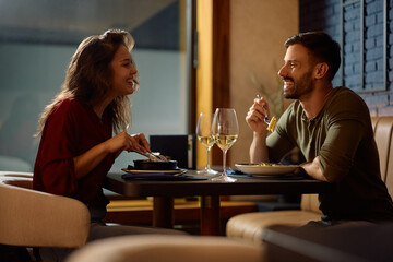 Happy couple talking while enjoying in a meal in restaurant.