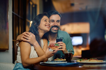 Embraced couple in love having lunch in pizzeria.