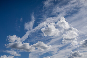 White fluffy clouds against a blue sky. Natural cloud formations in a bright daytime view.
