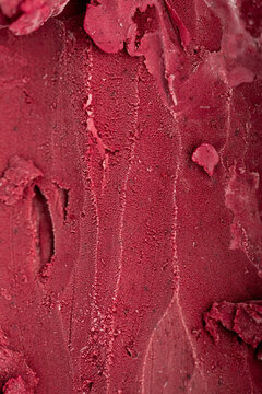 Close-up texture of rich red berry sorbet, vibrant and refreshing frozen dessert background