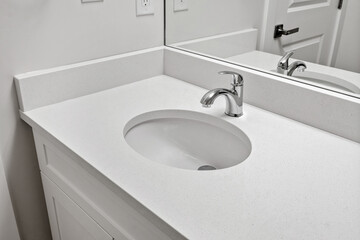 Sink with a faucet is on a white countertop