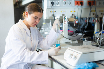 Portrait of young woman lab technician working in research laboratory, conducting experiment