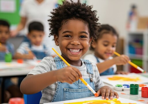 Happy boy painting in art class