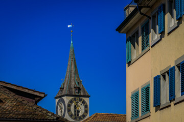 St Peter Church clock tower framed by historic buildings in Zurich, Switzerland