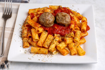  rigatoni  with pasta sauce and meatballs