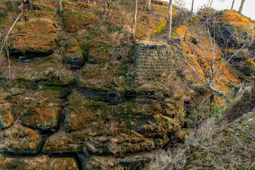 Ancient stone structure in mossy rocky landscape with sparse trees