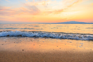 The ocean is calm and the sky is a beautiful orange color