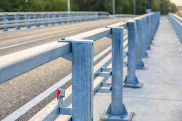Modern metal bridge guardrail design on empty road with perspective view