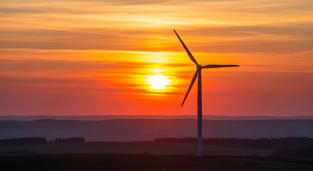 Obraz premium wind turbine at sunset, warm tones, blurred background of hills