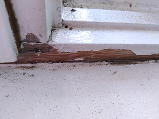 Old dirty window. building. Cracked white paint. Peeling painted background. House repair. Housing service. Plaster. Damaged. Repair. Home cleaning. Sill