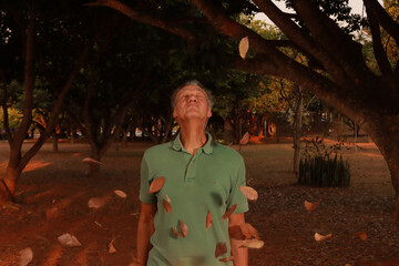 Mature Man with leaves falling down all around him