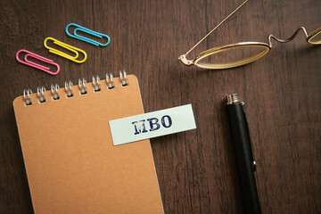Fototapeta premium There is sticky note with the word MBO. It is an abbreviation for Management by Objectives as eye-catching image.