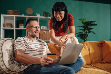Couple shopping online using laptop and credit card at home