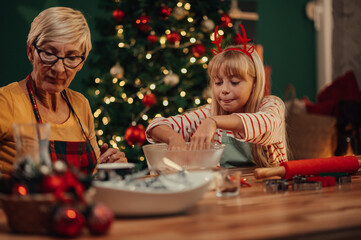 Grandmother and granddaughter baking christmas cookies together