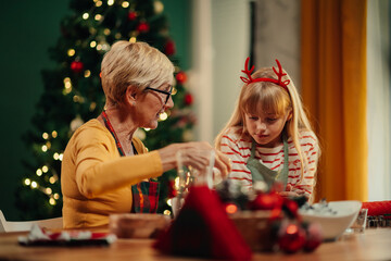 Grandmother and granddaughter making christmas decorations together