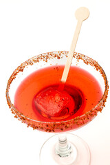 A vibrant red margarita with a chili-salt rim,  served in a glass on a bright white background.