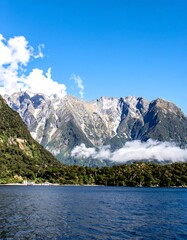 Obraz premium Mountainous lake shore, bright sky, hazy peaks