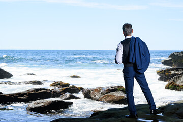 海でスーツを着たダンディーな中高年男性のポートレート