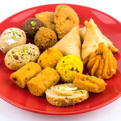 Assorted Indian sweets and snacks on a red plate