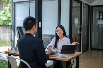 Businesswoman sharing ideas with male colleague during meeting in modern office