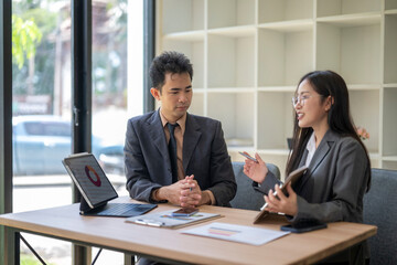 Businesswoman showing information on tablet to businessman during corporate meeting