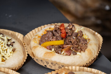 Delicious Mini Pizzas with Grilled Meat and Vegetables Served in Paper Liners