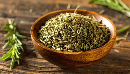 Fototapeta premium Dried rosemary in a wooden bowl on a rustic surface