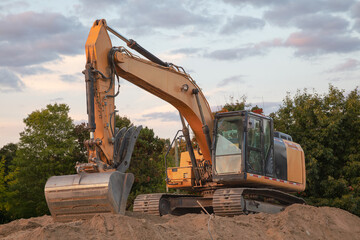 Yellow Excavator at Sunset on Construction Site