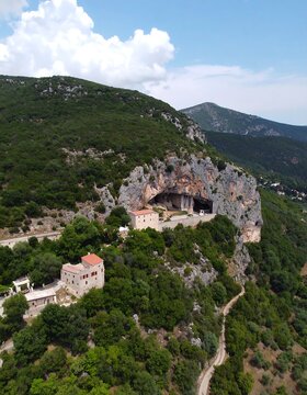 Mountain landscape with cave and buildings