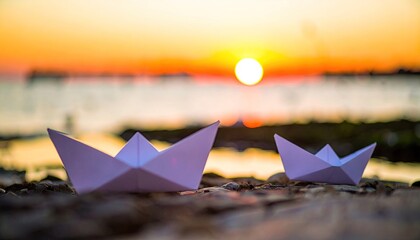 Two Paper Boats Sailing at Sunset on Ocean Shore