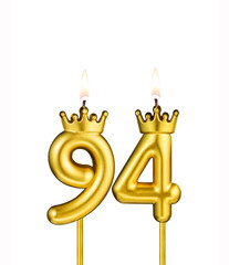 Golden number 94 birthday candle on white background