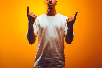 Generate an image of an individual in casual attire, specifically a white t-shirt and dark pants, standing in front of a solid orange backdrop.