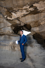 海の洞窟に立つスーツ姿の紳士　挑戦と決断を象徴するビジネスイメージ