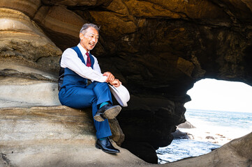 海の洞窟で深く考え込むスーツ姿の紳士