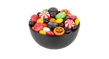 Assorted candies in a black bowl, including pumpkin shaped sweets and peppermint swirls on a surface