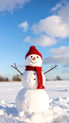 Snowman with red hat and scarf in snowy field