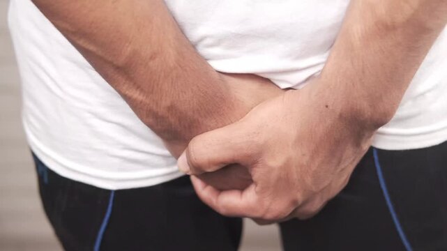 man holding his groin 4k video