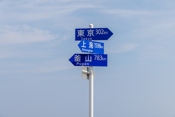 能登半島の先端にある東京・上海・釜山への距離を示す標識と青空