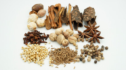 A vibrant array of spices, such as cloves, cinnamon, and nutmeg, are laid out, highlighting...
