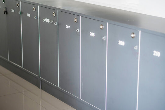 Row of gray metal lockers with numbers - Powered by Adobe