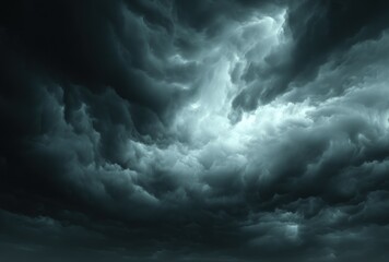 Obraz premium Ominous storm clouds fill the sky, their dark, swirling shapes contrasted by diffused, powerful light