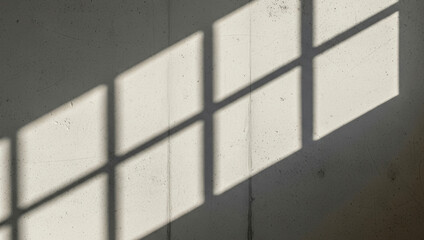Window light creates geometric shadows on a textured wall creating an abstract pattern that combines depth, symmetry, and artistic balance in a serene modern setting.