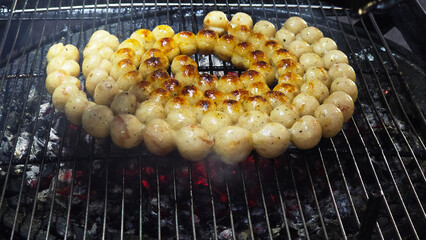 Grilled Thai Isaan sausage on charcoal grill