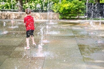Young boy running through the fountains at the Popup Water Park in St. Louis, Missouri