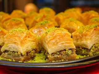 A platter of delicious pistachio baklava is sprinkled with bright green nut powder a classic and elegant presentation of the famous Turkish dessert