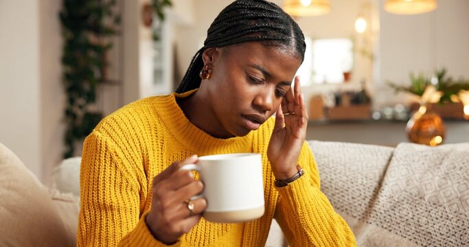 Stress, woman and coffee with headache on sofa from burnout, mental health or brain fog. Vertigo, beverage and black person with tension migraine in home with discomfort, uncomfortable ache and dizzy